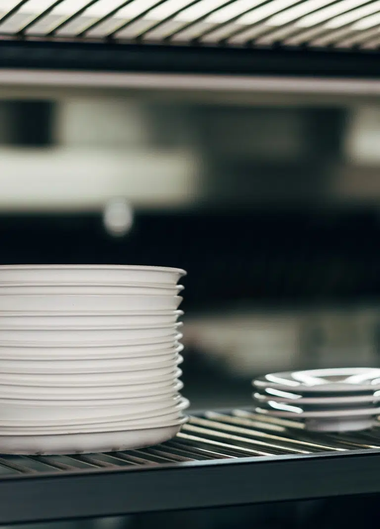 Professional Catering Equipment And Logistics Services in Melbourne, such as these white dinner plates stacked ready for meal service