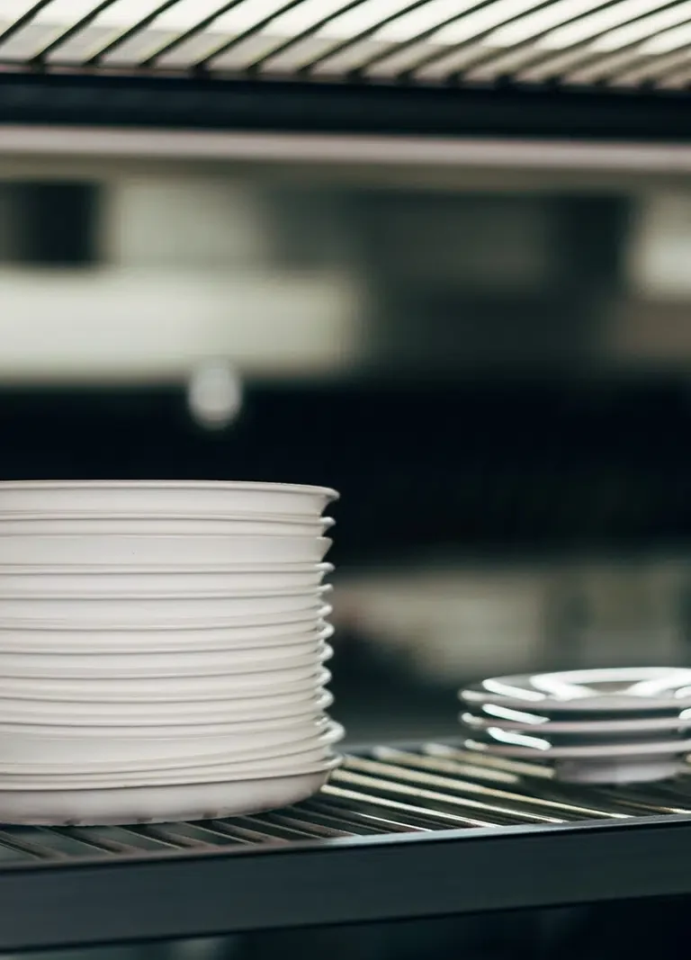 Professional Catering Equipment And Logistics Services in Melbourne, such as these white dinner plates stacked ready for meal service