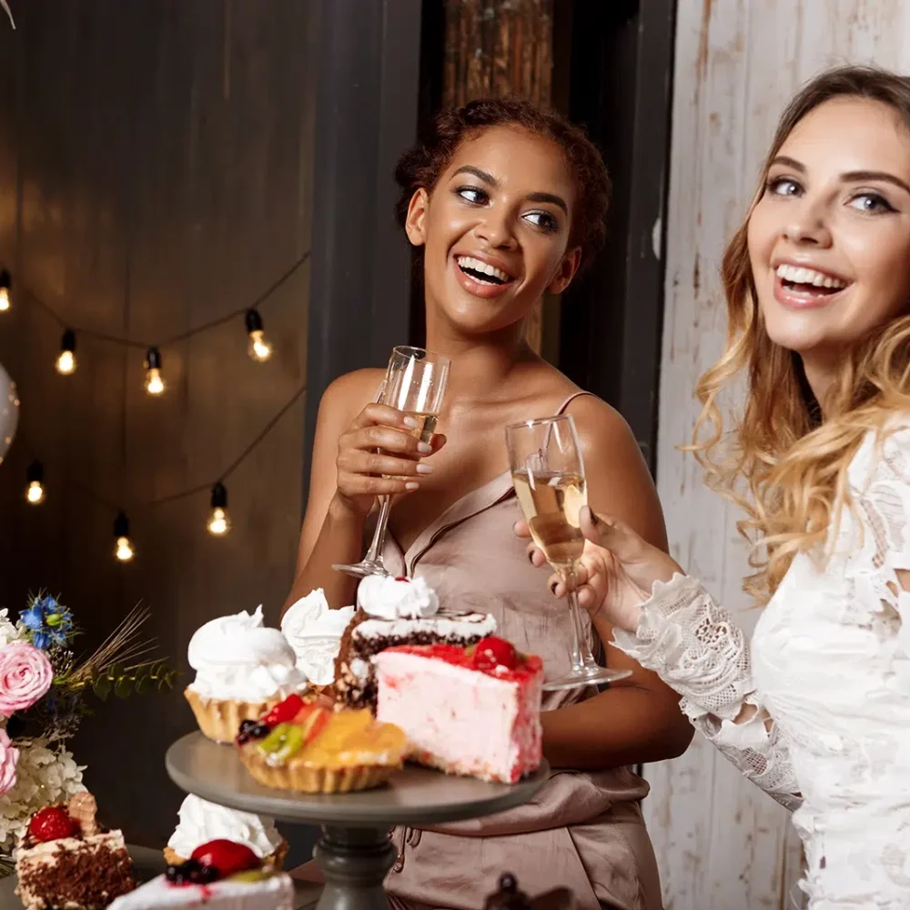 Two beautiful young ladies smiling and sipping Champagne at Pre-Wedding Celebration Catering in Melbourne